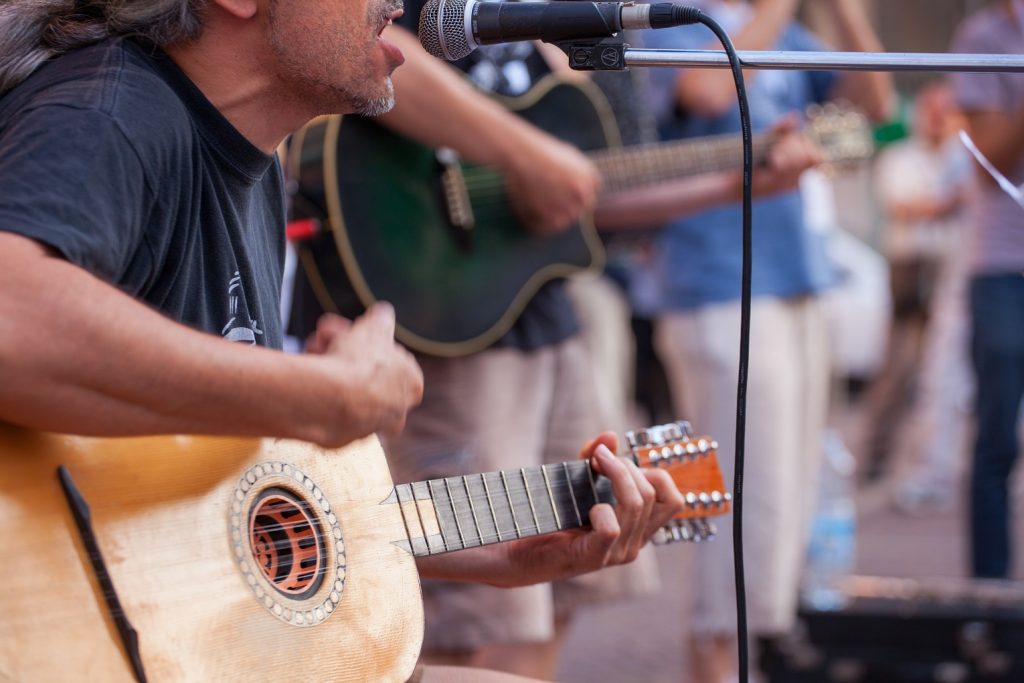 man strumming guitar on stage lloydminster hotels